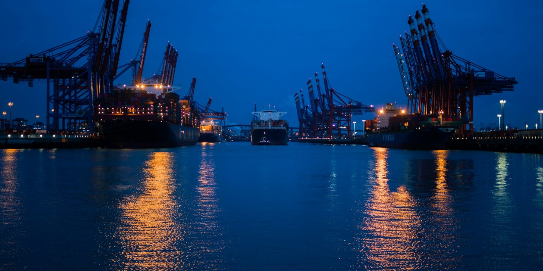 A harbour at night with ships and cranes